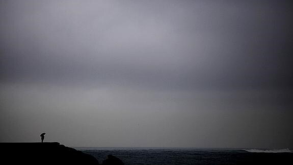 Una persona observa el mar desde la Playa de Riazor, en La Coruña.