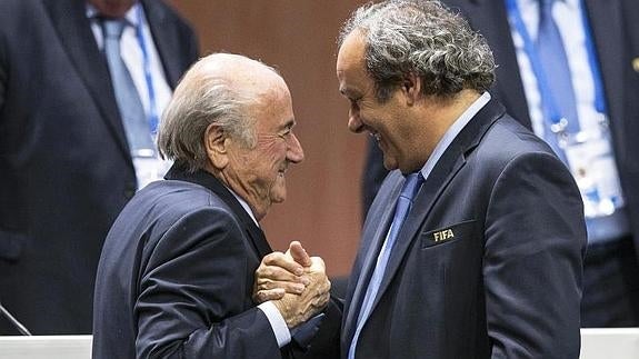 Blatter y Platini se saludan sonrientes. 