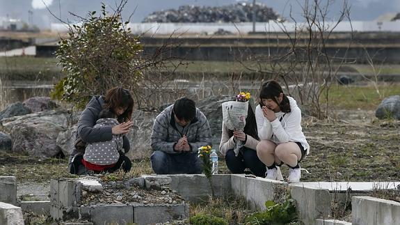 Un grupo de mujeres reza por los familiares fallecidos hace cinco años. 