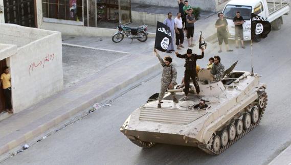 Yihadistas leales al Daesh desfilan en un tanque por la ciudad siria de Raqqa.