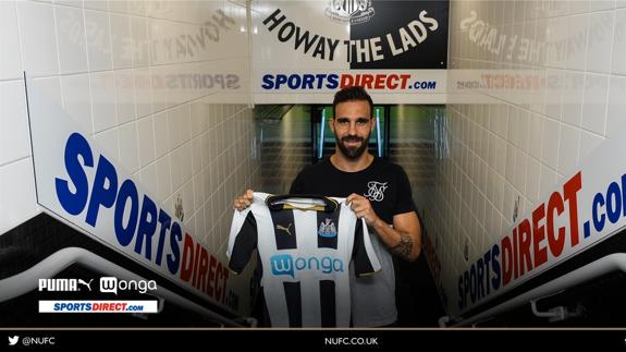 Jesús Gámez posa junto a la camiseta del Newcastle. 