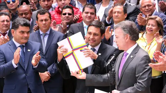 Santos (d), entrega al presidente del Congreso de Colombia, el texto definitivo del acuerdo de paz con las FARC.