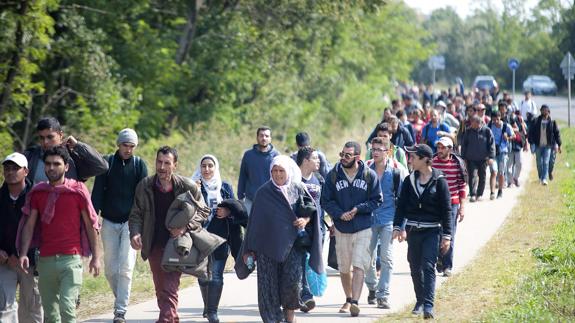 Inmigrantes caminan por una carretera de Austria.