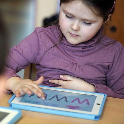 Niña de prescolar trabaja con su tableta en una escuela francesa. 