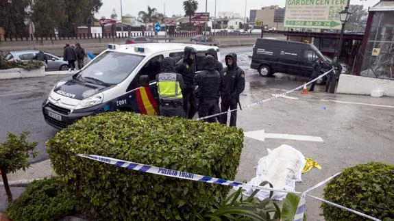 Agentes de la Policía, junto al cadáver de la mujer que ha muerto.