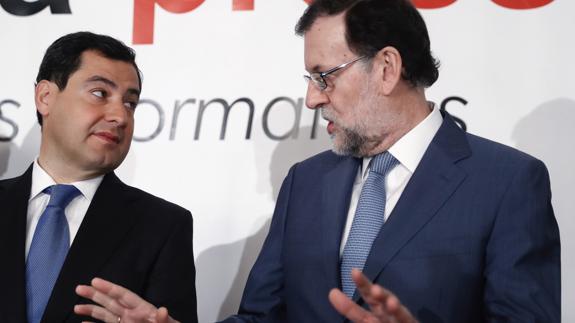 El presidente del Gobierno, Mariano Rajoy, conversa con el presidente del PP andaluz, Juanma Moreno. 