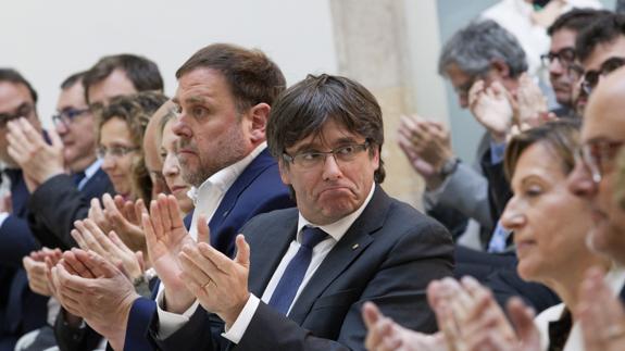 Carles Puigdemont (c) y Oriol Junqueras (i), en un acto de apoyo a Carme Forcadell (d).