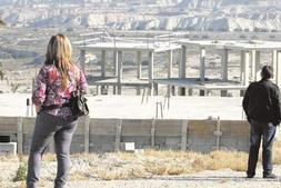 Un grupo de compradores de viviendas en la urbanización Trampolín Hills, ayer ante la estructura de una de las viviendas proyectadas. ::                             J. LEAL