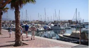 POLÉMICA. Unos paseantes observan los barcos amarrados en el nuevo puerto deportivo. / A.P.