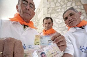 IDENTIDADES. Hieronides Moreno Benito (i), Filogonio Rica Herrero (c) y Marcelino García García (d) muestran el DNI, ayer, en la localidad burgalesa de Huerta de Rey. / EFE