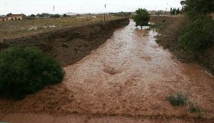 MUY CARGADA. La rambla de Los Belones, ayer por la tarde después	          de la tromba de agua en la ribera del Mar Menor. / J. M. RODRÍGUEZ / AGM