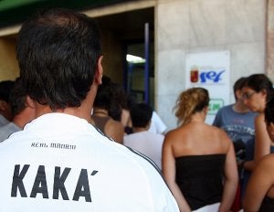 Un desempleado murciano, ataviado con               la camiseta del  jugador del Real Madrid Kaká -que cuesta 85 euros-,  hace cola por la mañana a las puertas de la oficina del Servicio de Empleo y                 Formación para sellar su tarjeta del paro. / EDUARDO BOTELLA / AGM