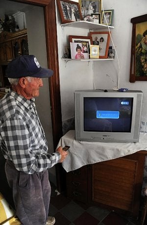 Juan Navarro con el mando de su televisor intenta sintonizar un canal en Torre de Nicolás Pérez. ::                             A. GIL / AGM