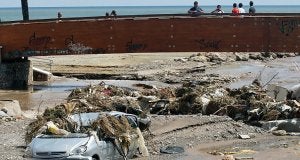 Un coche, semisepultado por fango, piedras y matorrrales en la desembocadura de la rambla de Las Culebras de Águilas, tras la tromba de agua del 21 de agosto. ::                             EDU BOTELLA /                             AGM