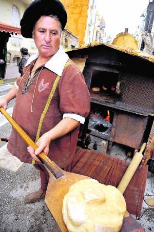 Recién cocinado. Con una pinta deliciosa, el pan sale del horno. Y, por si faltara algo, el fuego que se ve al fondo invita a llevárselo a casa y disfrutarlo en el hogar. Calentito y en buena compañía.