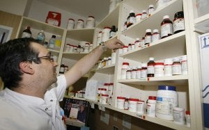 Un farmacéutico ordena las estanterías de su oficina. ::                             JUAN LEAL