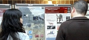 Dos participantes en el congreso de alumnos leen varios pósteres presentados. ::                             ABEL F ROS / ENFOQUE