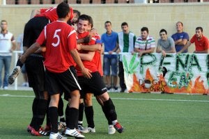 Ramón, capitán del Pulpileño, recibe de Monje Carrillo el trofeo de la Copa Federación. A la derecha, el Huércal Overa celebra un gol en el campo de Los Garres. ::                             A. DURÁN / AGM