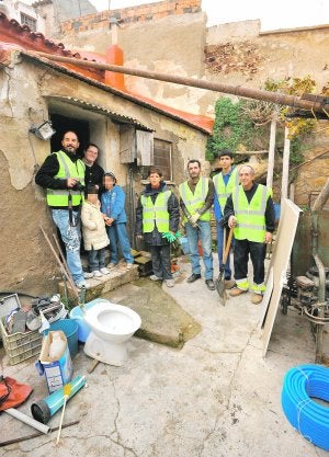 Voluntarios del proyecto 'Chapuzas sin fronteras', en el patio de la casa donde están interviniendo estos días. ::
PACO ALONSO / AGM