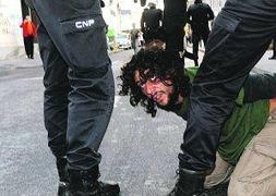 Dos policías reducen a un chico en la calle Bando de la Huerta durante la carga policial. Foto: Nacho García/ AGM