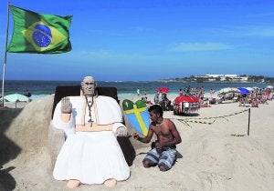 Un escultor da los últimos retoques a una estatua de arena del Papa Francisco en la playa de Copacabana de Río de Janeiro . ::                             MARCELO SAYÃO / EFE