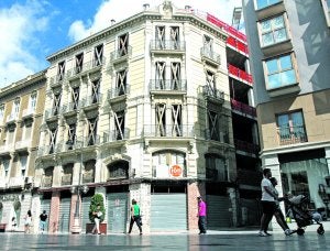 Edificio de Pedro Conesa, con la puerta de su pasaje protegida con una chapa, en el chaflán. ::  P. S./AGM