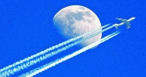 Un avión de pasajeros, un Boeing 747, deja una densa estela tras su despegue.