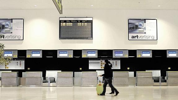 Un solitario viajero pasa por los mostradores del aeropuerto de Ciudad Real, vacíos, antes del cierre de las instalaciones, en 2012.