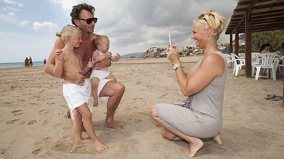 Una familia de turistas se hace una foto en la playa de Bolnuevo, en Mazarrón