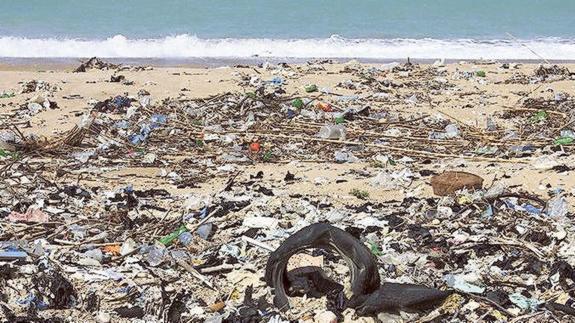 Aspecto de una playa a la que la marea ha llevado toneladas de residuos plásticos y otras basuras que flotaban por el mar.