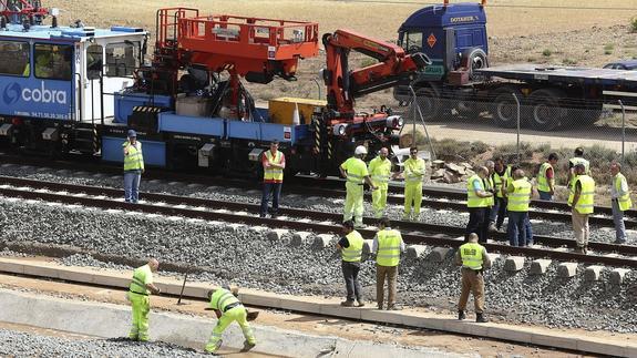 Varios operarios trabajan junto a las vías.