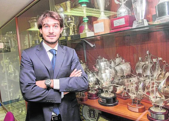 Javier Marco posa ante la vitrina de trofeos de la sala de juntas del estadio Cartagonova. :: 