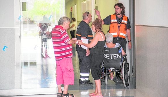 Sanitarios, pacientes y familiares, en la puerta de ingresos en ambulancia, ayer. 