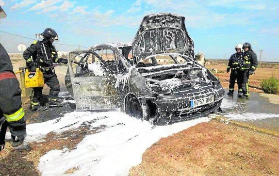 Los Bomberos lanzan espumógeno en el interior del coche, para acabar con los últimos rescoldos del incendio. :: lv
