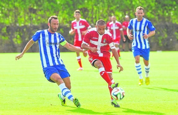 Quinín, capitán de La Unión, persigue a Jorge Luque en el amistoso ante el Cartagena. agm