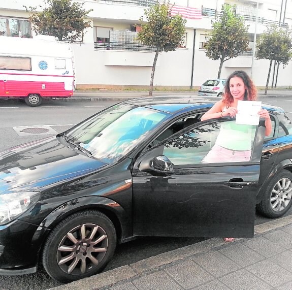 Lohitzune posa junto a su coche, en Santurce, mientras muestra la providencia de apremio para abonar la multa de 224 euros. 