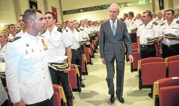 El ministro, entre militares firmes, entra en el salón de actos donde inauguró el curso de Infantería de Marina.