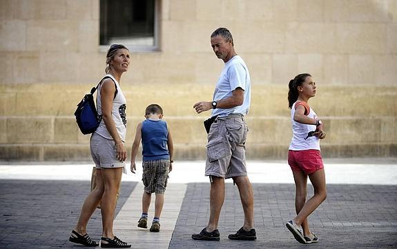 Una familia de turistas extranjeros, ayer en la plaza del cardenal Belluga . 