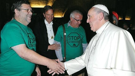 El Papa Francisco saluda al cura Joaquín Sánchez en presencia del salesiano José Antonio Vives, ambos con la camiseta verde de la PAH.