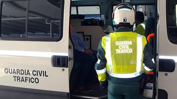 Un agente junto al detenido en el furgón de la Benemérita