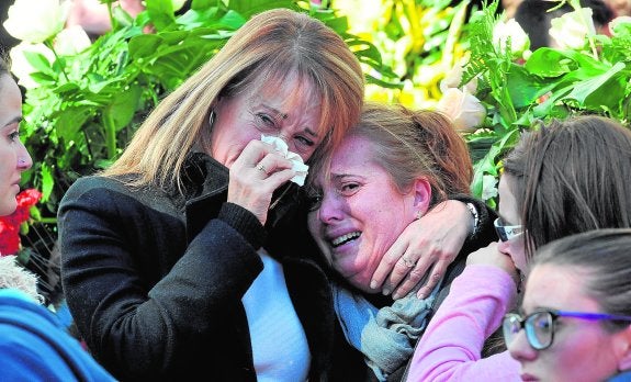 Dos familiares se consuelan en el pabellón municipal, durante el funeral. :: GUILLERMO CARRIÓN / AGM
