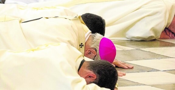 El arzobispo de Granada, Francisco Javier Martínez (c), tumbado ante el altar mayor de la Catedral granadina, ayer.