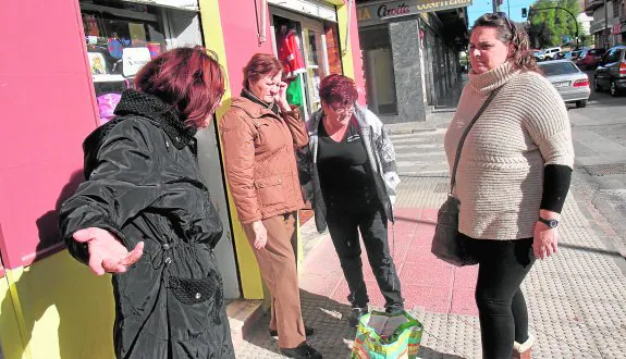 Vecinas y comerciantes de la Urbanización Mediterráneo hablan en la puerta de una tienda sobre la situación del barrio. PABLO SÁNCHEZ/AGM
