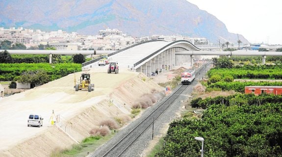 Obras del AVE entre Beniel y Orihuela, donde se aprecian la plataforma nueva y el antiguo trazado con el paso de un tren de cercanías.