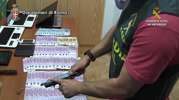 Billetes, armas y otros objetos incautados a la banda desmantelada.