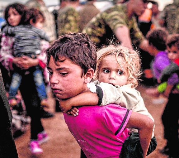 Dos niños kurdos llegan a la frontera entre Turquía y Siria, tras los bombardeos de la ciudad turca de Suruc, en septiembre pasado. 