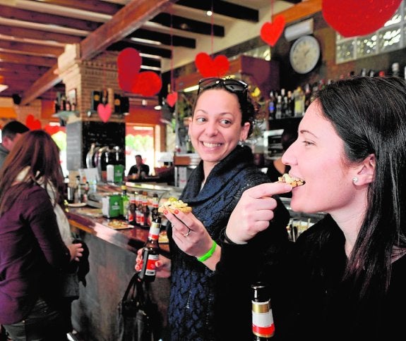 Dos jóvenes prueban una de las tapas del concurso. 