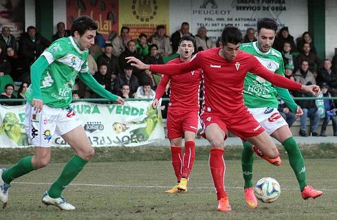 Gerard Olvia conduce el balón seguido por dos rivales del Astorga. 