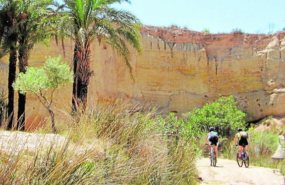 Dos ciclistas recorren los alrededores del río Chícamo, en Abanilla.