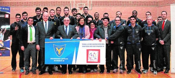 Mendoza, junto a la presidenta de Astrapace, Rosa García, con la plantilla detrás. 